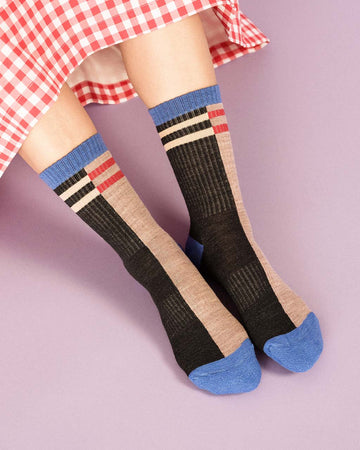 model wearing two-tone split crew socks with black and white stripe side and tan and red stripe side