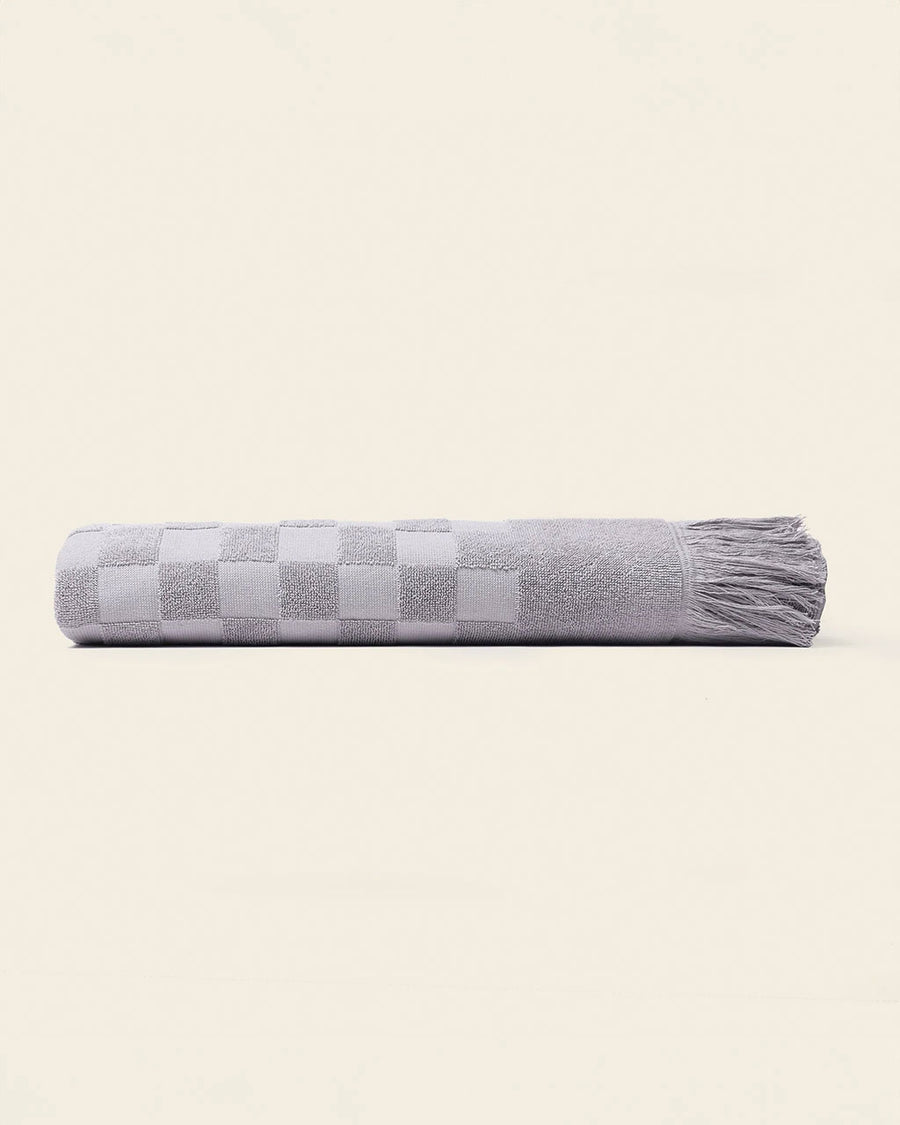sideview of folded grey checkered bath towel