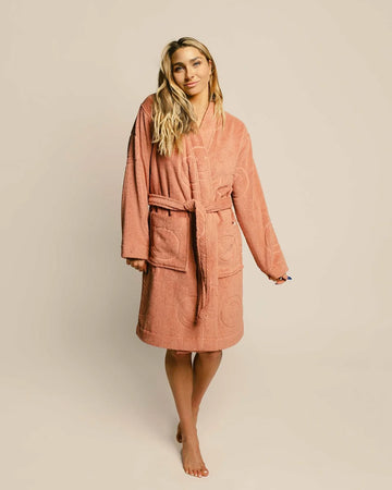 model wearing terra cotta robe with embossed smiley design and front patch pockets