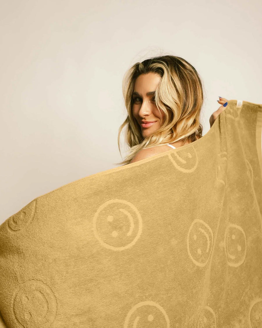 model holding mustard embossed smiley towel