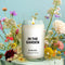 'in the garden' 13.5 oz soy candle surrounded by colorful wildflowers