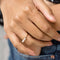 up close of model wearing gold band ring with clear crystal baguette stone