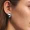 model wearing silver ball dome huggie earrings