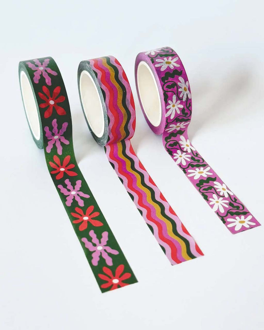 unrolled set of three abstract floral washi tape rolls: pink and white floral, colorful wavy squiggles, and pink and red abstract floral