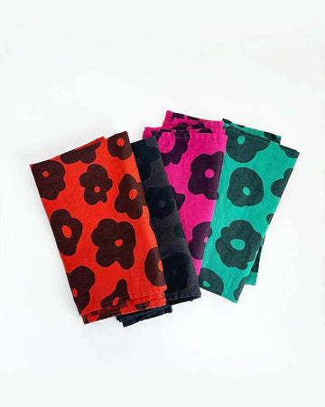 set of 4 napkins in red abstract flower, black abstract flower, hot pink abstract flower, and teal abstract flower
