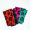set of 4 napkins in red abstract flower, black abstract flower, hot pink abstract flower, and teal abstract flower