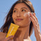 model putting kinfield daily dew sunscreen on her face