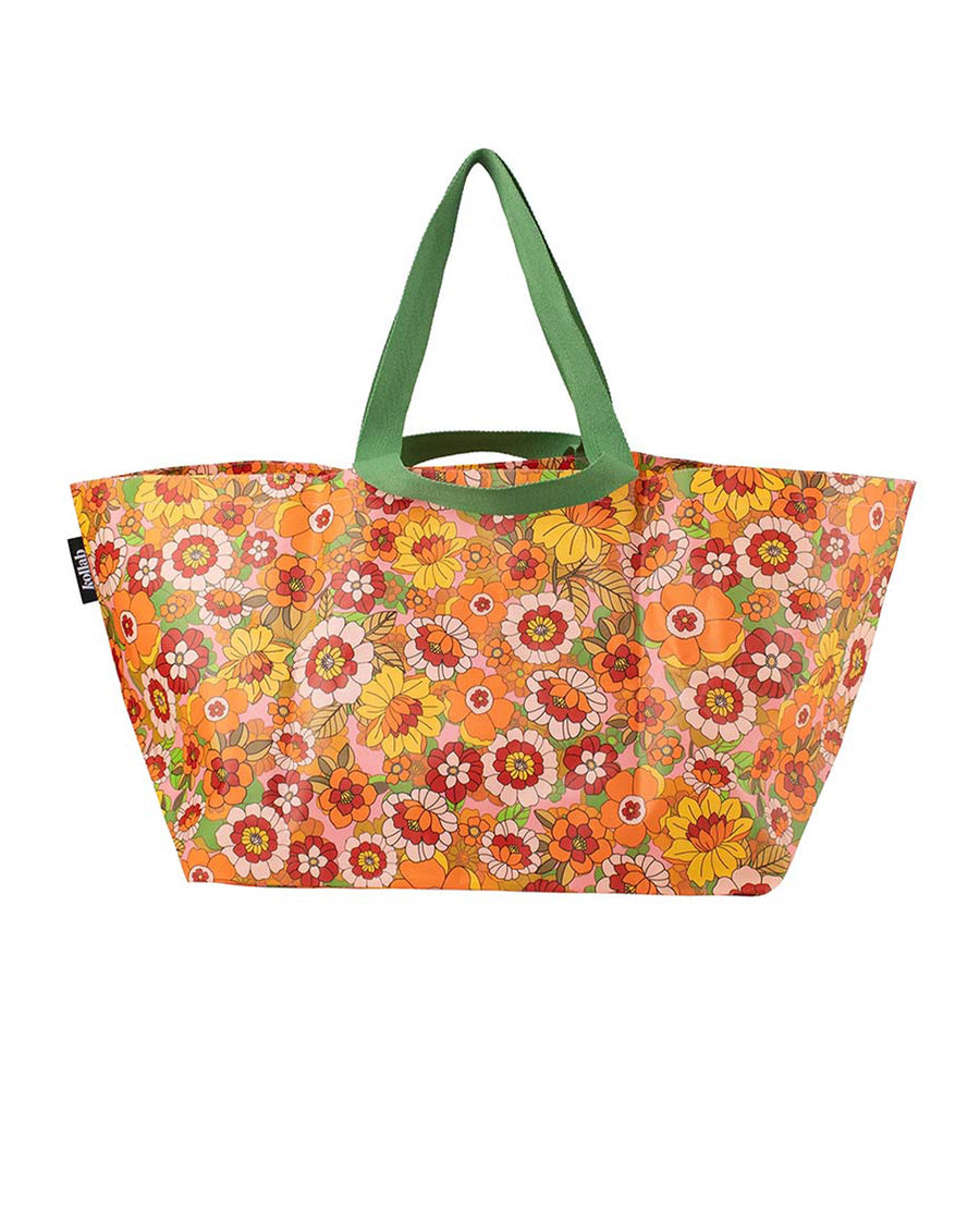 large beach bag with pink, yellow, and orange 70's inspired floral print and green strap
