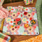 medium foldable picnic mat with colorful patchwork print with picnic items on it