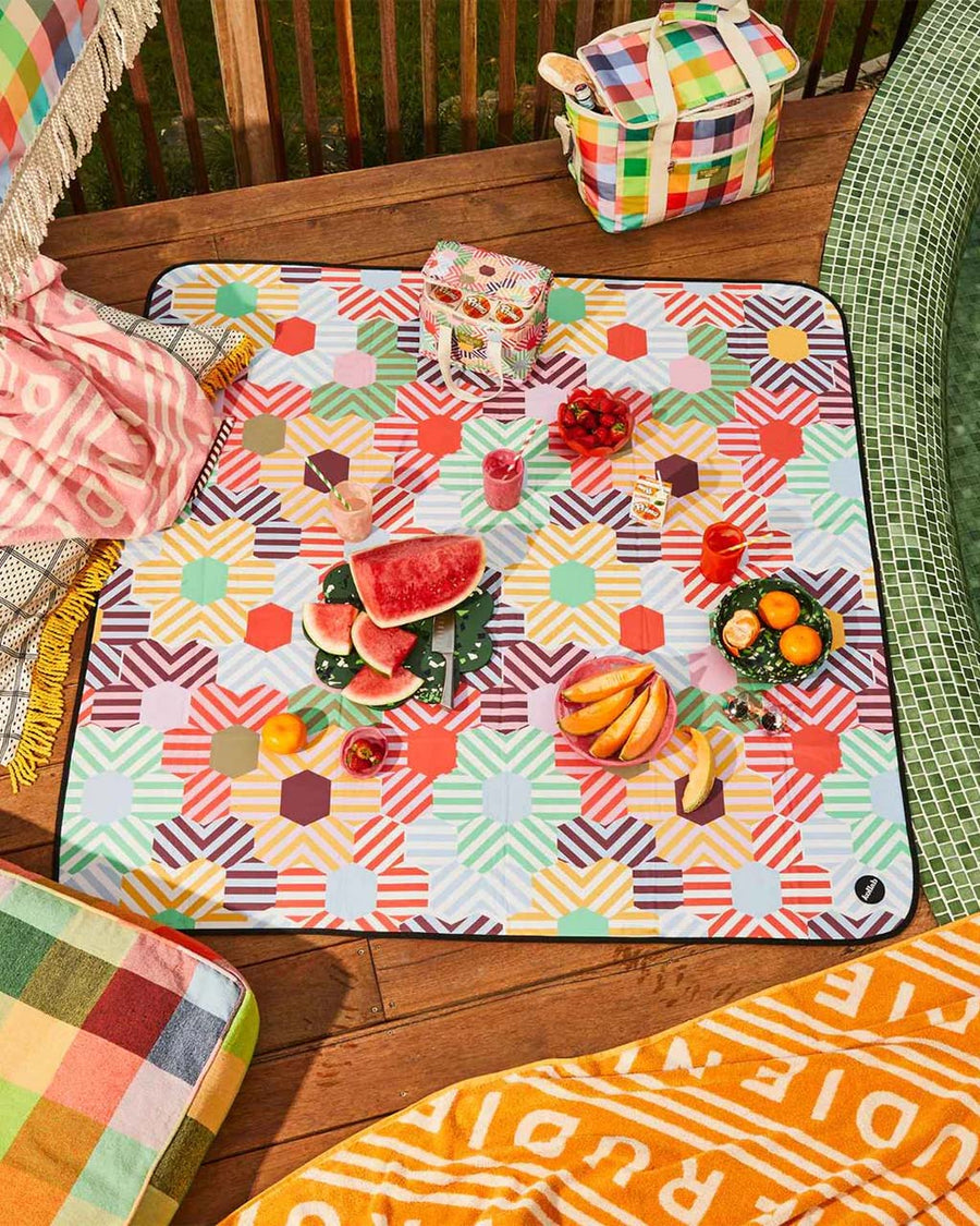 medium foldable picnic mat with colorful patchwork print with picnic items on it