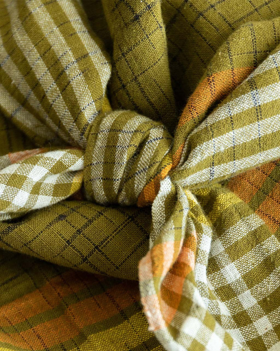 up close of knot on retro inspired dark green, yellow, and orange plaid scarf