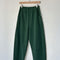 pine green arc pants with side pockets on a hanger