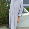 side view of model wearing relaxed fit blue and white vertical stripe shin length shirtdress