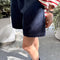 side view of model wearing navy cotton shorts