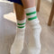 model wearing white crew socks with two kelly green stripes on the top