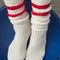 model wearing white crew socks with two red stripes on the top