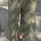 model wearing army green pants with workmen patches down the front and inner drawstring