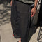 side view of model wearing black pants with workmen patches down the front and inner drawstring