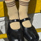 Model wearing tan socks with three brown stripes at the top and black flats