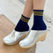 model wearing navy crew socks with three gold stripes at the top
