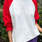 model wearing white relaxed fit raglan tee with red sleeves
