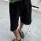 frontview of model wearing black cotton relaxed fit bermuda shorts