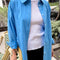model wearing un-buttoned oversized lake blue button down top