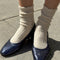 model wearing white ribbed scalloped socks with flats