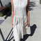 model wearing white cotton midi dress with henley button neckline and drop waist