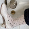 side view of model wearing oatmeal socks with dainty all-over black dots