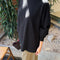 sideview of model wearing black cotton long sleeve tunic with mockneck