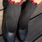 model wearing black socks with red ruffle trim and black flats