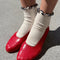 model wearing white socks with navy ruffle trim and red flats