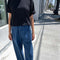 model wearing blue denim relaxed fit pants with black tee