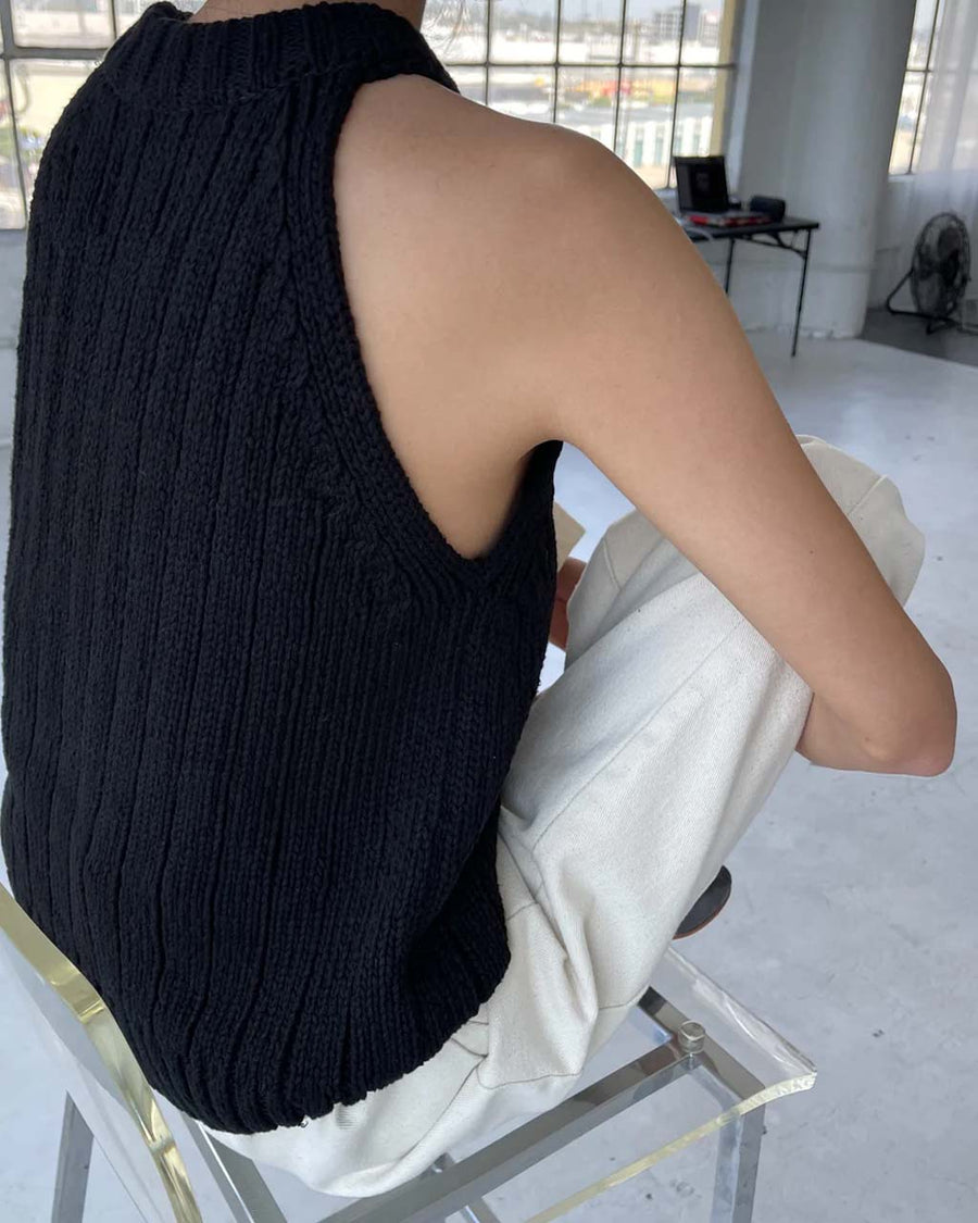 back view of model wearing black knit halter sweater top 