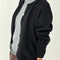 side view of model wearing un-buttoned black cotton cardigan
