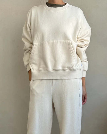 model wearing cream pullover cotton sweatshirt with kangaroo pocket