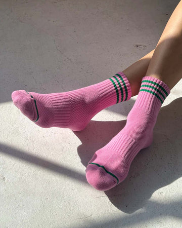 model wearing bubblegum pink socks with green stripe cuffs