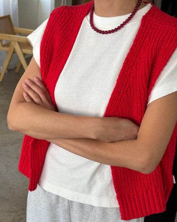model wearing red knit open front 'granny' sweater vest