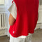 back view of model wearing red knit open front 'granny' sweater vest