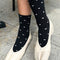 model wearing tall black socks with dainty white hearts