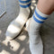 model wearing cream high crew socks with double blue stripes at the top