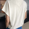 back view of model wearing cream cap sleeve tee with side slits