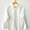 white relaxed fit button front shirt with side vents and collar on a hanger