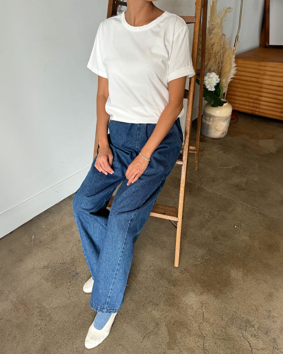 model wearing white organic cotton tee with slight distressing on the sleeves and neckline