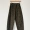 greenish leopard print arc pants with side pockets and side leg panels on a hanger