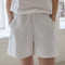 model wearing white cotton shorts with side pockets