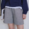 model wearing thin navy and white stripe shorts with side pockets and exposed hem at the bottom