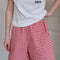 front view of model wearing red and white gingham cotton shorts with side pockets