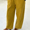 model wearing green olive corduroy arc pants with side panels and pockets